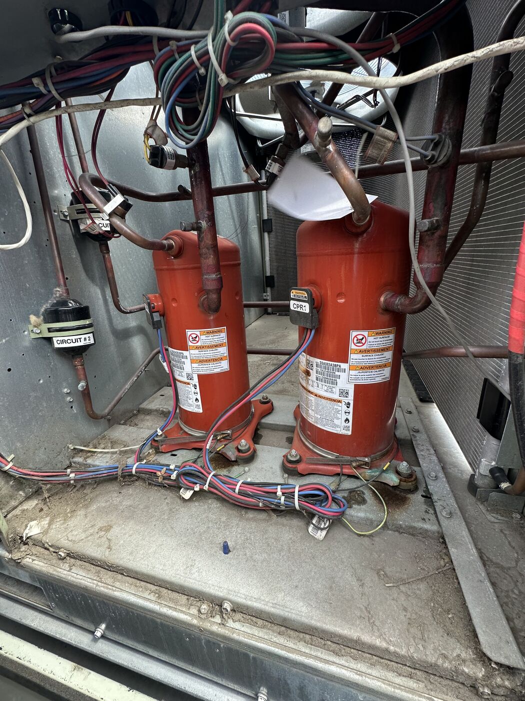 Interior of an AC condenser unit showing compressor wiring during an electrical service call